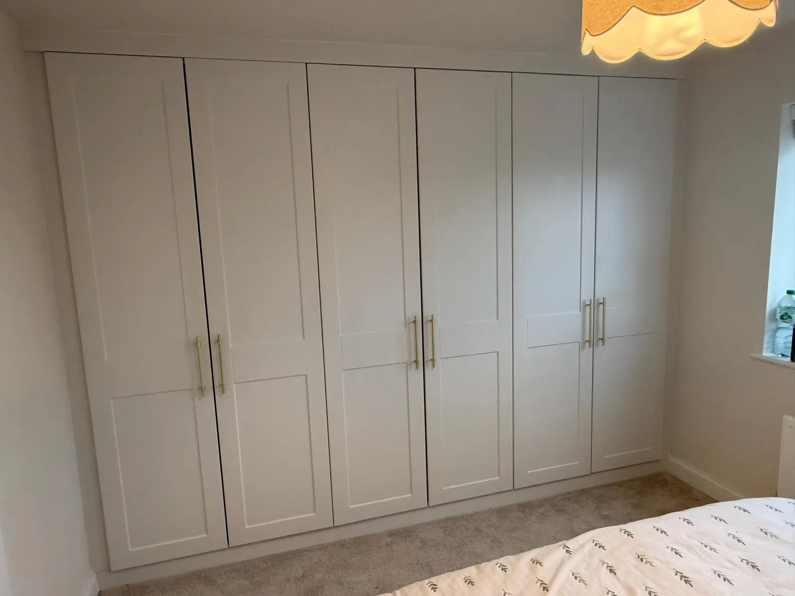 Custom full-wall fitted wardrobe doors in master bedroom